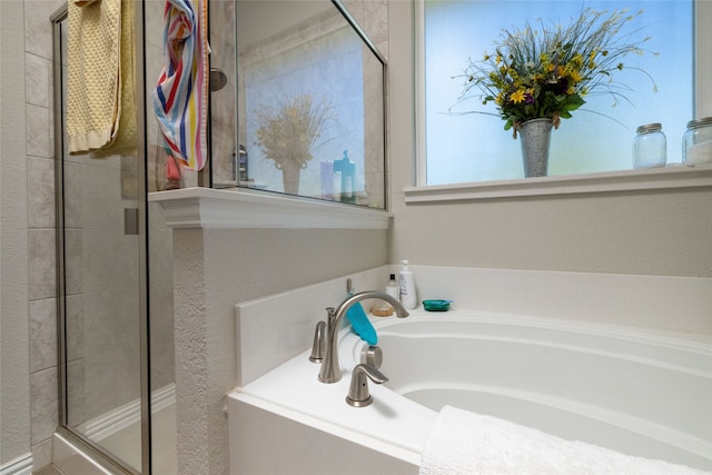 bathroom featuring shower with separate bathtub