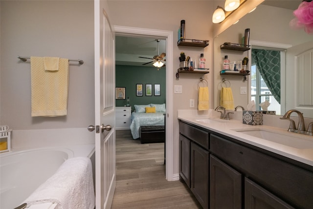 bathroom with a tub to relax in, vanity, ceiling fan, and hardwood / wood-style flooring