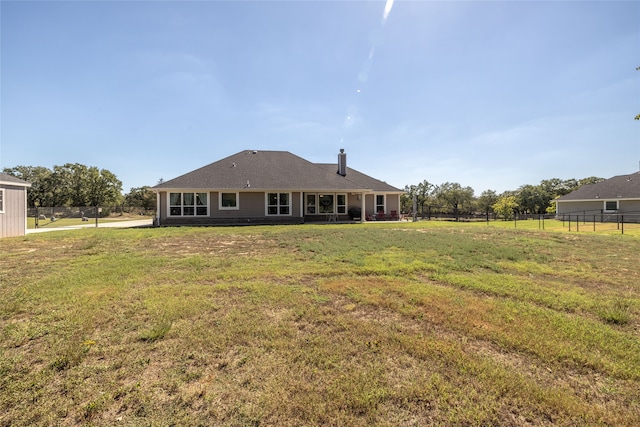 rear view of property with a yard