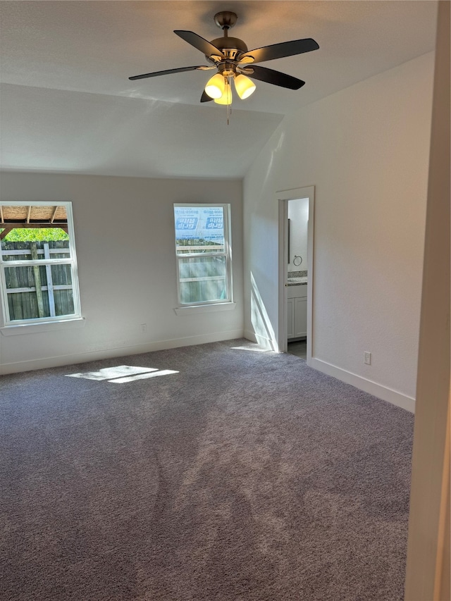 carpeted empty room featuring vaulted ceiling and ceiling fan