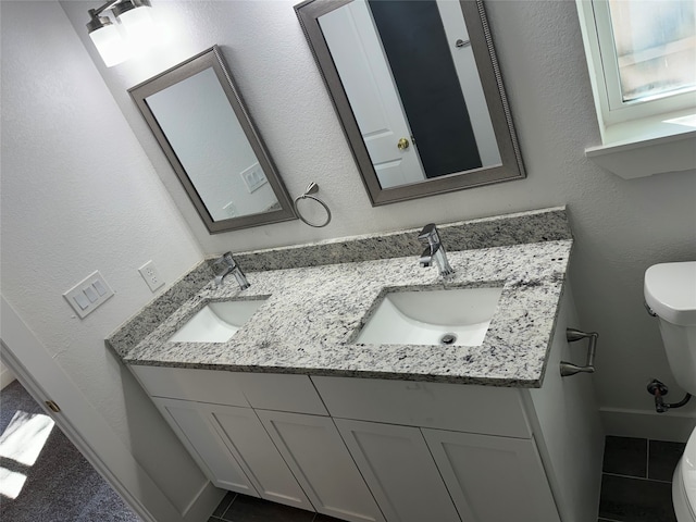 bathroom with tile patterned flooring, vanity, and toilet