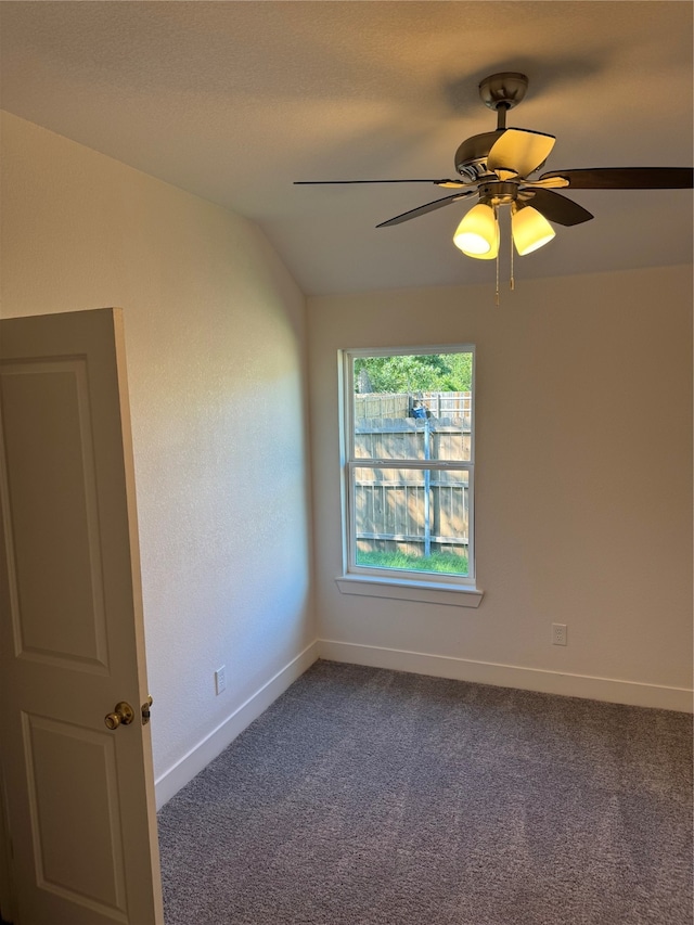 unfurnished room with lofted ceiling, ceiling fan, and carpet flooring