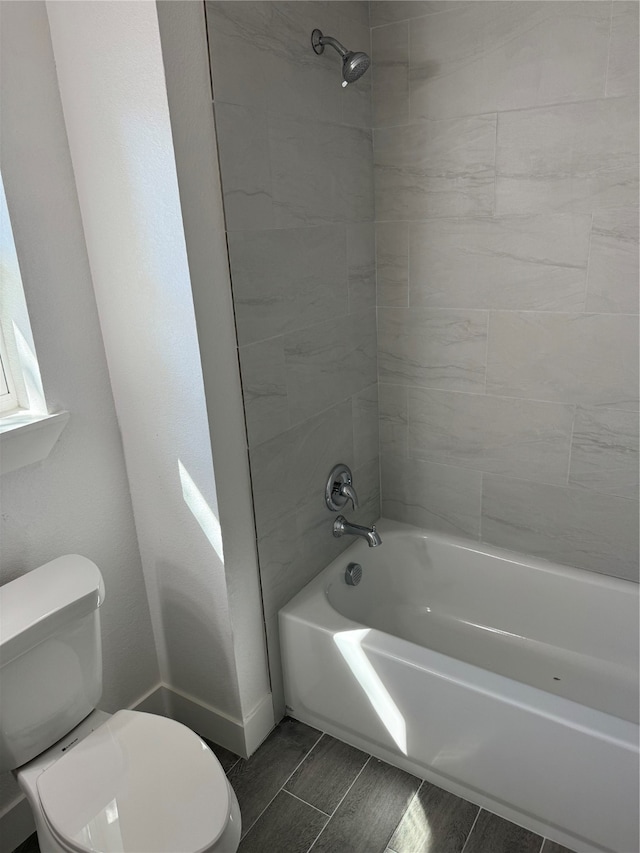 bathroom with tiled shower / bath and toilet