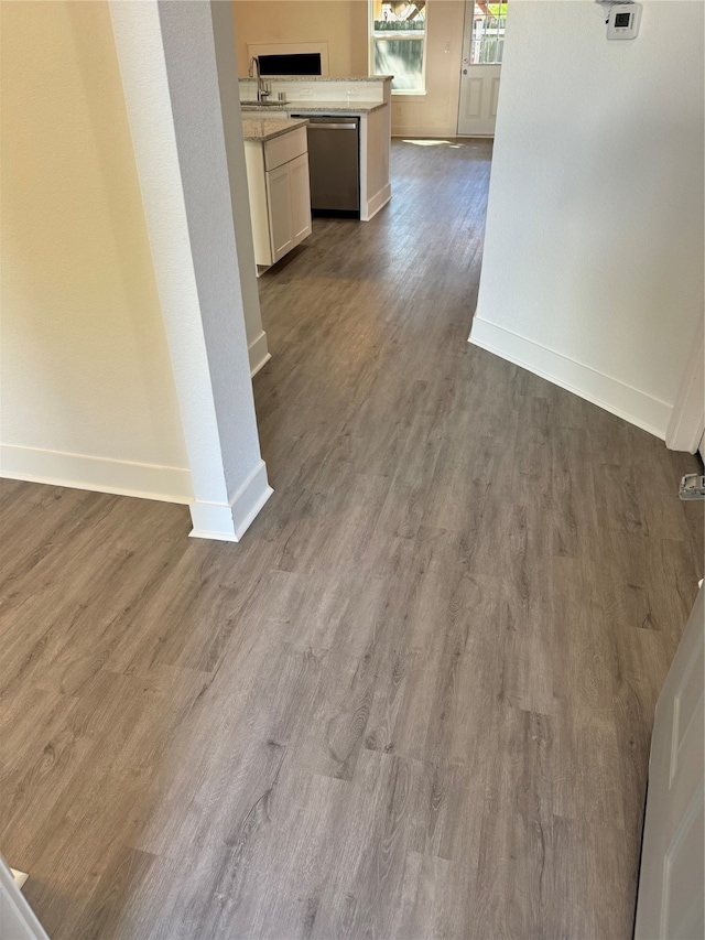 hallway with hardwood / wood-style flooring and sink