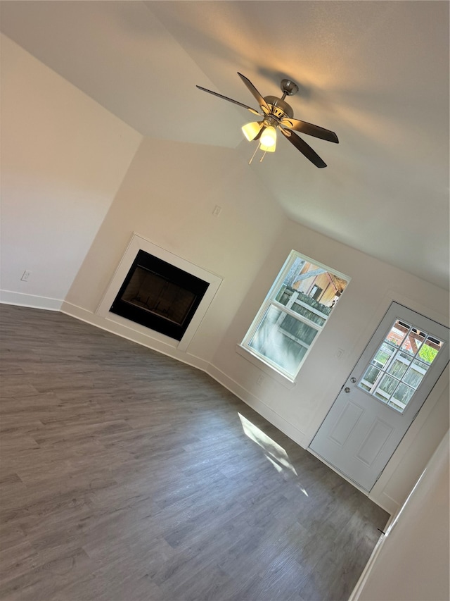 unfurnished living room with ceiling fan, dark hardwood / wood-style floors, and vaulted ceiling