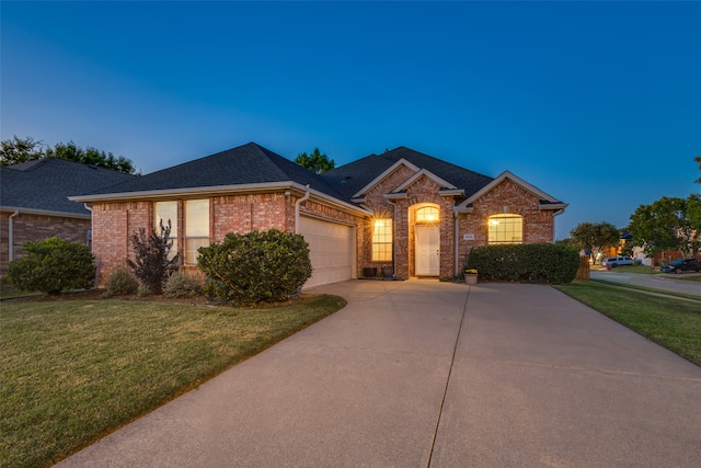 single story home featuring a garage and a lawn