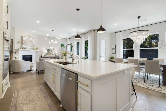 kitchen with white cabinetry, sink, an island with sink, stainless steel dishwasher, and dark hardwood / wood-style flooring