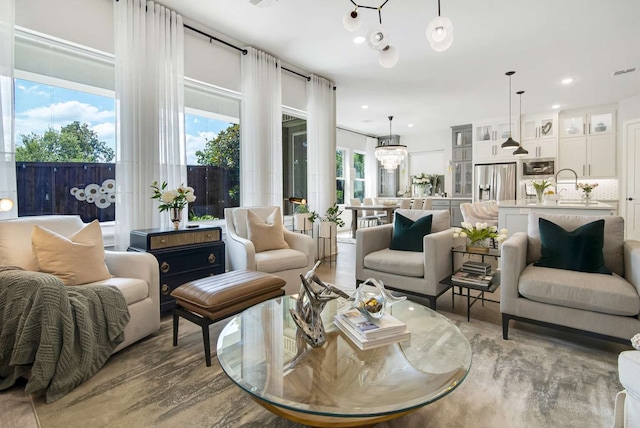 living room with an inviting chandelier and light wood-type flooring