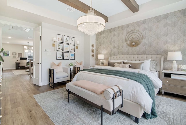 bedroom featuring wood-type flooring, beam ceiling, and a notable chandelier