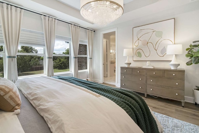 bedroom featuring light wood-type flooring and a notable chandelier