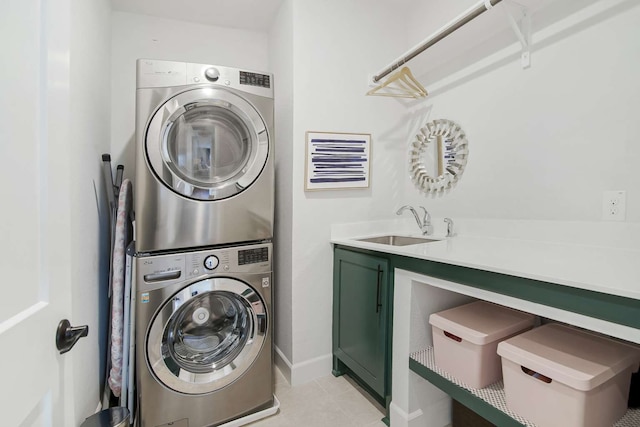 clothes washing area with stacked washing maching and dryer, cabinets, light tile patterned floors, and sink