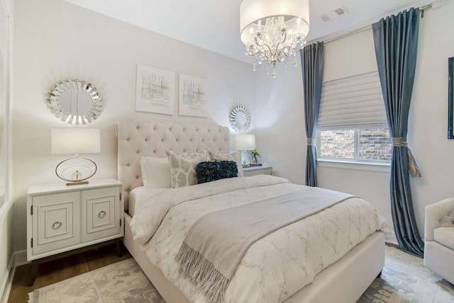 bedroom featuring hardwood / wood-style flooring and a chandelier