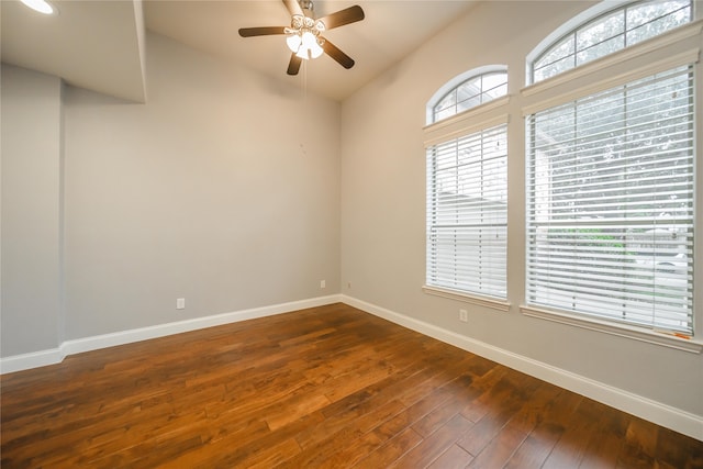 empty room with vaulted ceiling, ceiling fan, and dark wood-type flooring