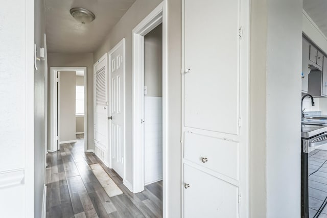 hall featuring wood-type flooring and sink