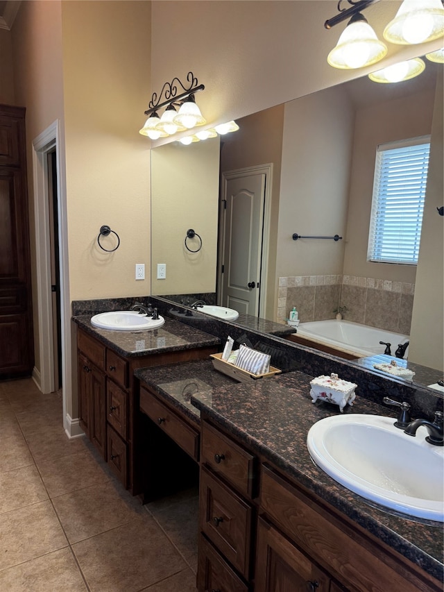 bathroom with an inviting chandelier, tile patterned floors, vanity, and a bathing tub