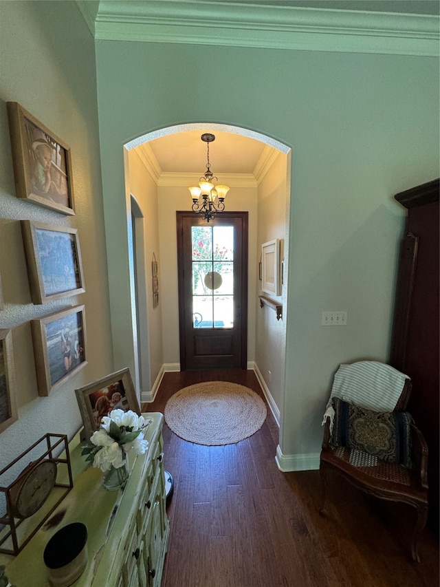 foyer with an inviting chandelier, crown molding, and dark hardwood / wood-style floors