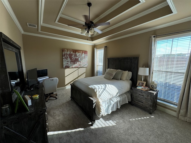 carpeted bedroom featuring a raised ceiling, ornamental molding, and ceiling fan