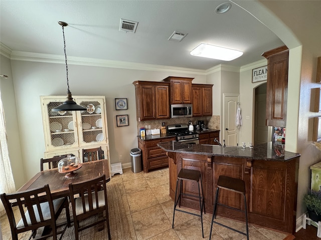 kitchen featuring appliances with stainless steel finishes, light tile patterned flooring, tasteful backsplash, kitchen peninsula, and ornamental molding