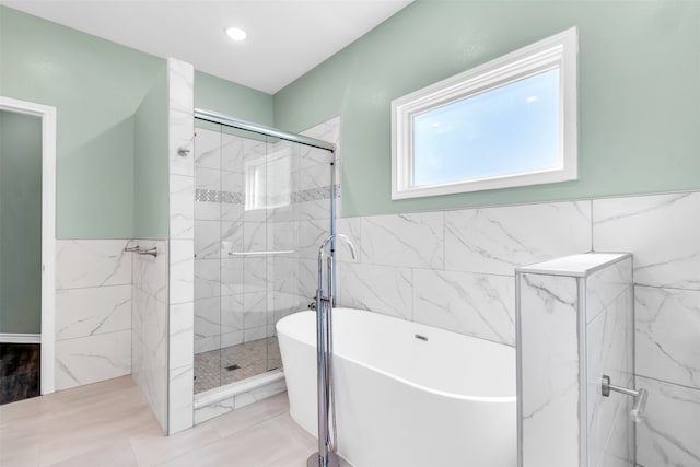 bathroom featuring tile walls, tile patterned floors, and shower with separate bathtub