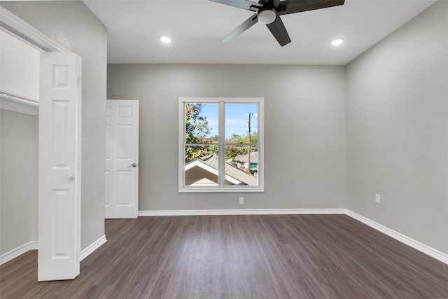 unfurnished bedroom with ceiling fan and dark wood-type flooring