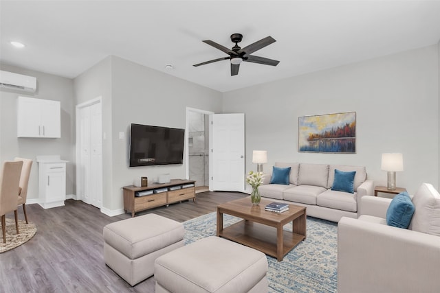 living room with a wall unit AC, ceiling fan, and hardwood / wood-style floors