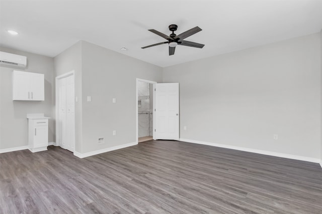 interior space with ceiling fan, dark hardwood / wood-style floors, and a wall unit AC