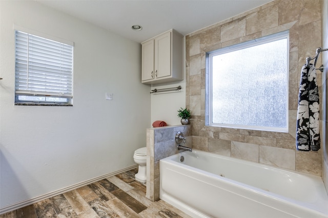 bathroom featuring hardwood / wood-style floors, a bathtub, and toilet