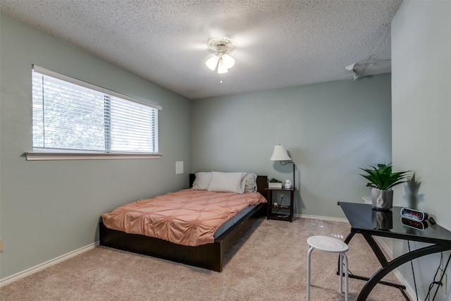 carpeted bedroom with ceiling fan and a textured ceiling