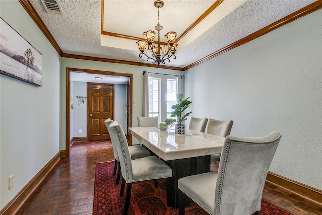 dining area featuring an inviting chandelier, a textured ceiling, dark parquet flooring, and ornamental molding