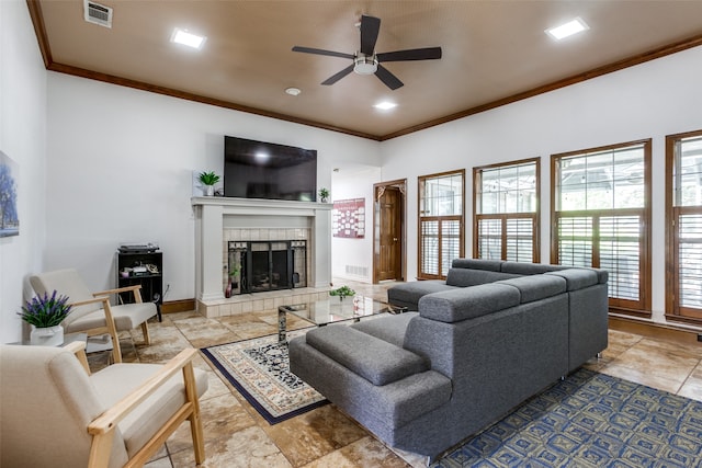 living room with ornamental molding, ceiling fan, and a fireplace