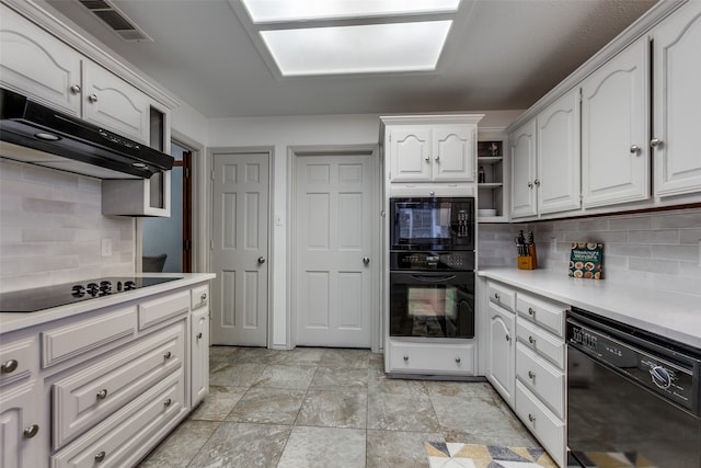 kitchen with white cabinets, black appliances, and tasteful backsplash