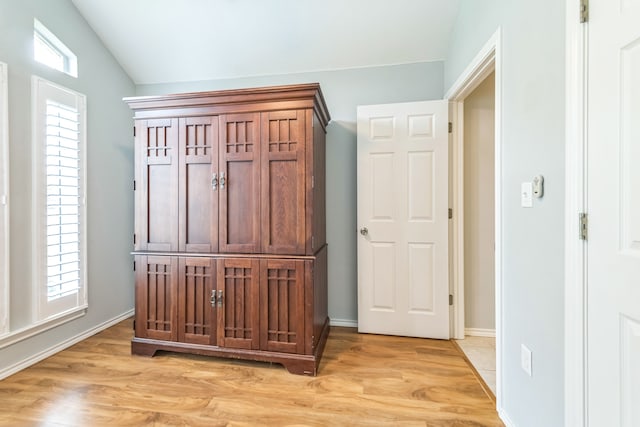 bedroom featuring light wood-type flooring and vaulted ceiling