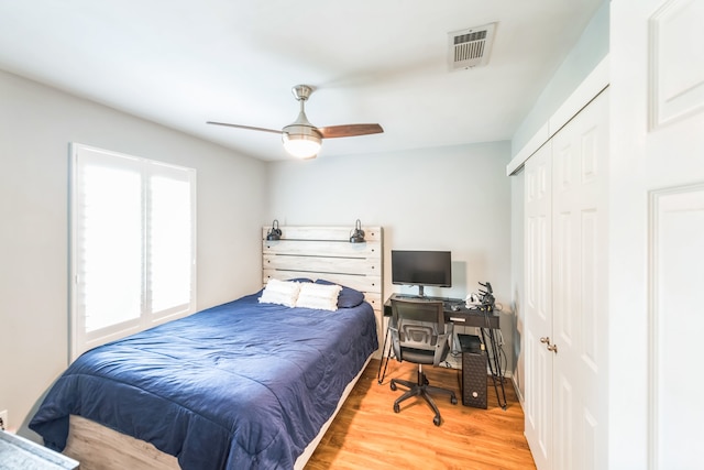 bedroom featuring wood-type flooring, ceiling fan, and a closet