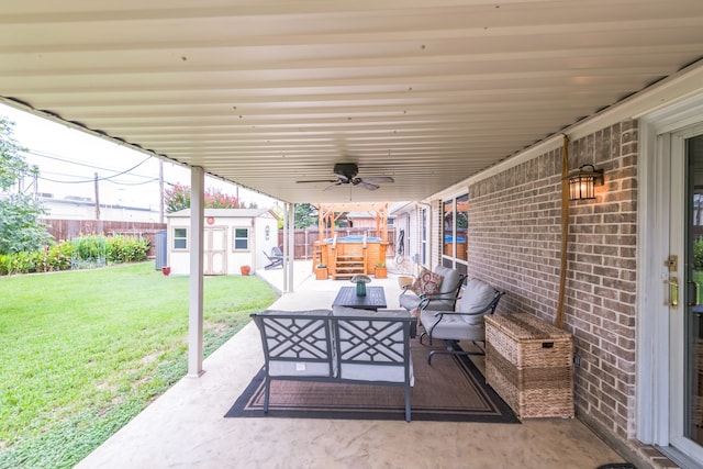 view of patio featuring a storage unit, ceiling fan, and outdoor lounge area