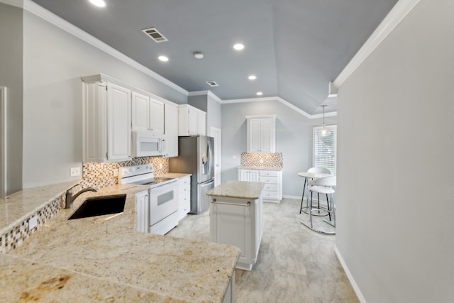 kitchen with white cabinetry, kitchen peninsula, white appliances, and a kitchen island