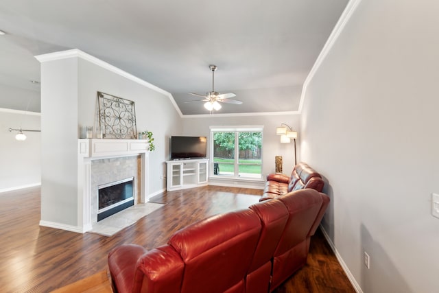 living room with a tile fireplace, vaulted ceiling, hardwood / wood-style floors, crown molding, and ceiling fan