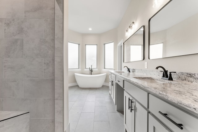 bathroom featuring vanity, a bath, and tile patterned floors