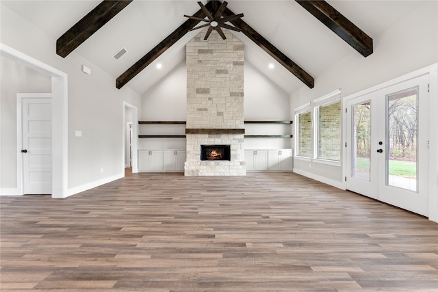 unfurnished living room featuring hardwood / wood-style floors, a fireplace, and high vaulted ceiling