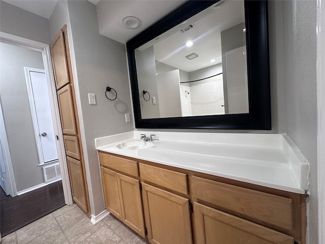 bathroom featuring a shower, tile patterned flooring, and vanity