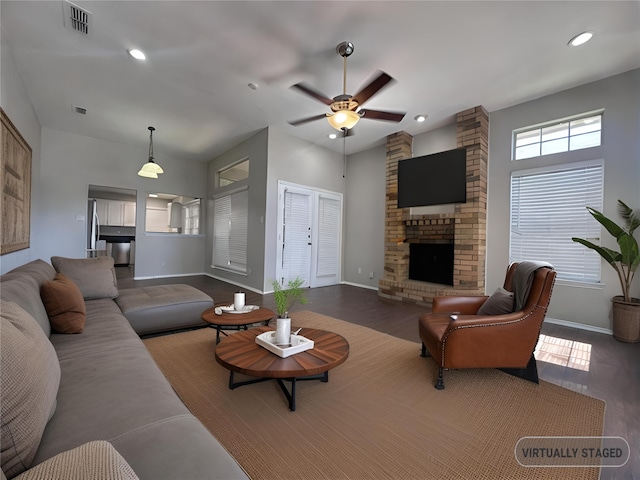 living room featuring a fireplace, dark hardwood / wood-style floors, and ceiling fan