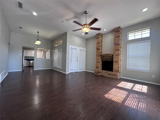 unfurnished living room with ceiling fan, a fireplace, and dark wood-type flooring