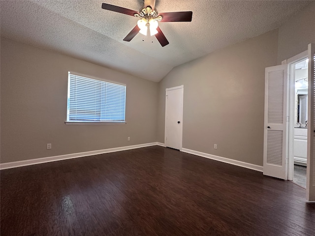 spare room with lofted ceiling, ceiling fan, dark hardwood / wood-style floors, and a textured ceiling