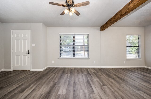 spare room featuring ceiling fan, baseboards, beamed ceiling, a textured ceiling, and dark wood-style flooring