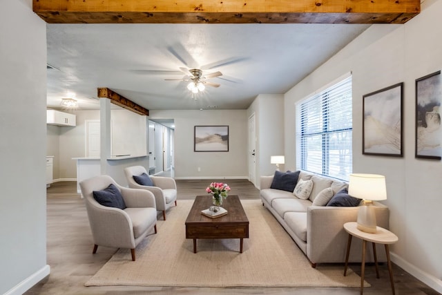 living room with wood finished floors, baseboards, and ceiling fan