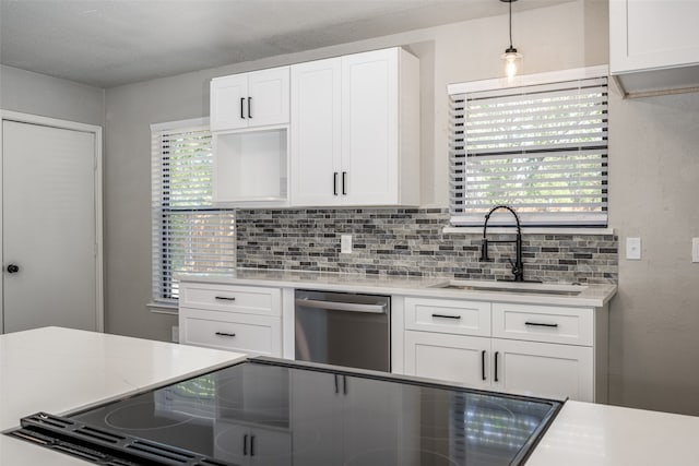 kitchen with dishwasher, light countertops, decorative backsplash, white cabinetry, and a sink