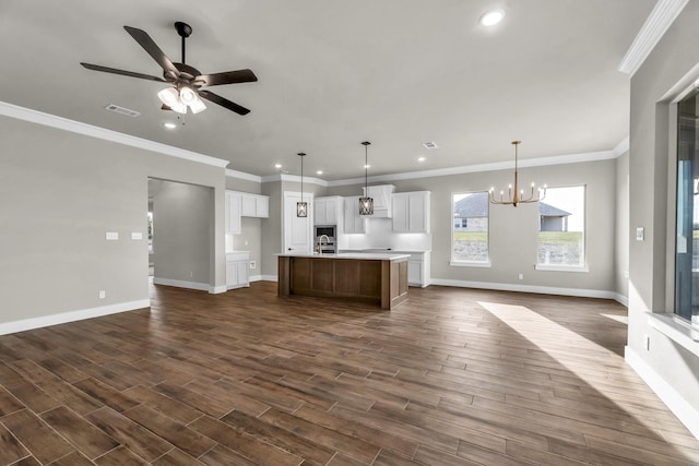 kitchen with a center island with sink, ceiling fan with notable chandelier, dark wood-type flooring, and hanging light fixtures