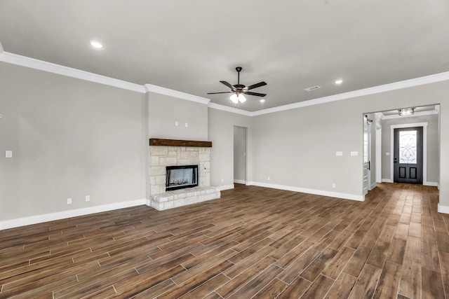 unfurnished living room featuring a stone fireplace, ceiling fan, dark wood-type flooring, and ornamental molding