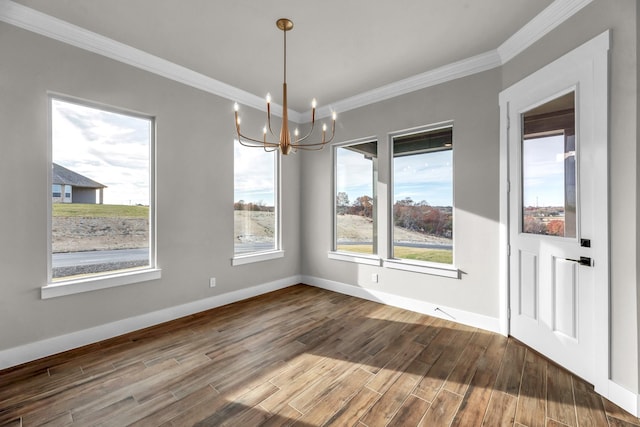 unfurnished dining area with hardwood / wood-style flooring, an inviting chandelier, and crown molding