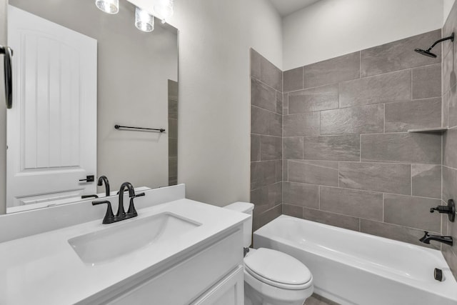 full bathroom featuring tiled shower / bath combo, toilet, and vanity