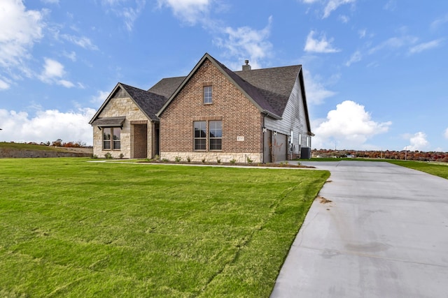 view of front of house featuring a garage, a front lawn, and central air condition unit